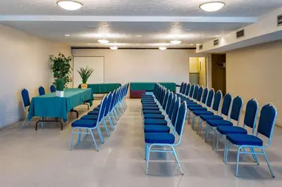 a conference room with a green table and blue chairs at Quality Hotel & Suites in Sherbrooke
