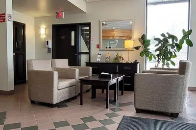 a waiting room with chairs and a table in a lobby at Quality Hotel & Suites in Sherbrooke