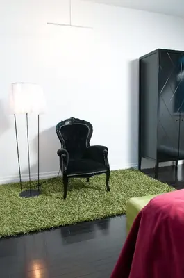 a black chair and a television in a living room at Hotel Chez Swann in Montréal
