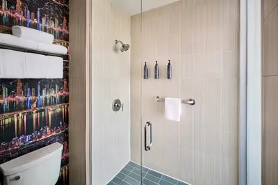 a bathroom with a shower and a toilet at Aloft Montreal Airport in Dorval