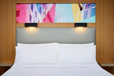 a bed with two white pillows in a room at Aloft Montreal Airport in Dorval