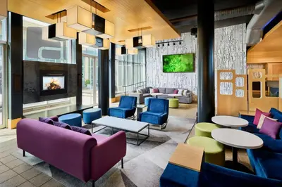 a lobby with colorful furniture and a fireplace at Aloft Montreal Airport in Dorval