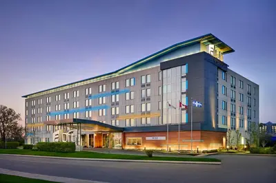 a large building with a flag on top of it at Aloft Montreal Airport in Dorval