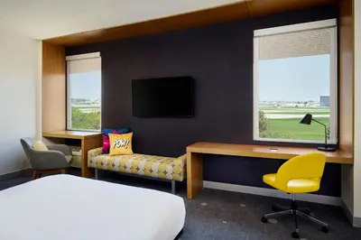 a hotel room with a bed and a desk and a tv at Aloft Montreal Airport in Dorval