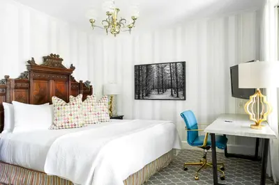 a bedroom with a bed and a desk and a chair at Manoir Hovey, Relais & Châteaux in North Hatley