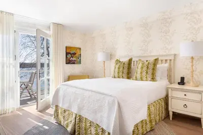 a bedroom with a large white bed with yellow pillows at Manoir Hovey, Relais & Châteaux in North Hatley