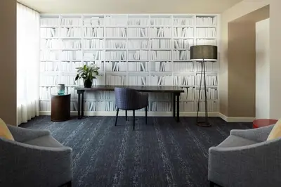 a room with a desk and a wall of books at DoubleTree By Hilton Montreal in Montréal