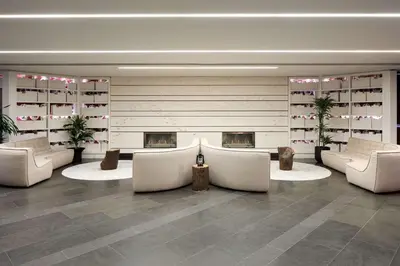 a lobby with white chairs and a fireplace at DoubleTree By Hilton Montreal in Montréal