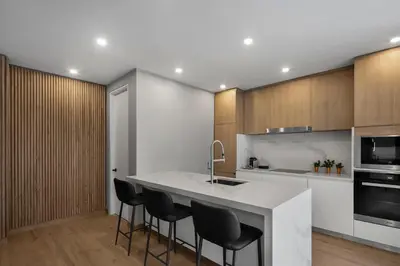 a kitchen with a white counter and black appliances at Hôtel Le Germain Montréal in Montréal