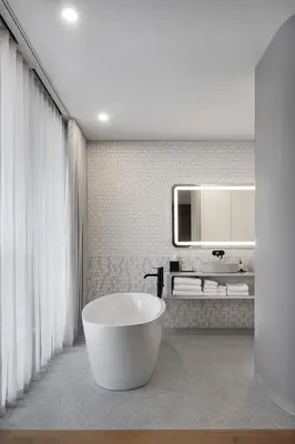 a bathroom with a large tub and a mirror at Hôtel Le Germain Montréal in Montréal