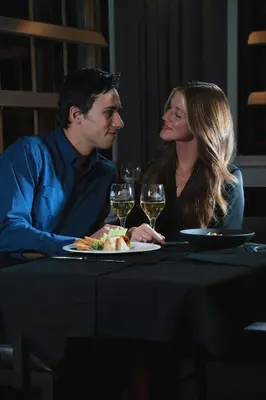 a man and woman sitting at a table with wine glasses at Auberge Godefroy in Bécancour