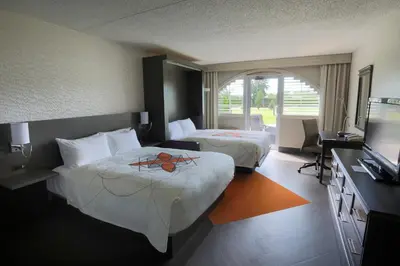 a hotel room with two beds and a television at Auberge Godefroy in Bécancour