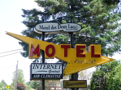 a sign for a motel with alot of signs at Motel des Deux Lacs in Waterloo
