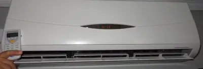 a person holding a remote control in front of a microwave at Motel des Deux Lacs in Waterloo