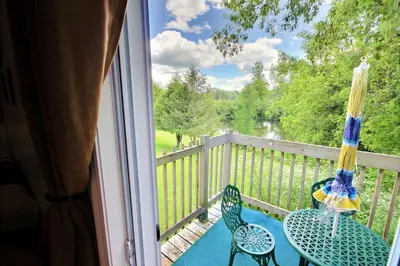 a balcony with two tables and an umbrella at Motel des Deux Lacs in Waterloo