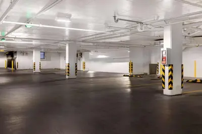 an empty parking garage with white walls and yellow and white columns at Home2 Suites By Hilton Montreal Dorval in Dorval
