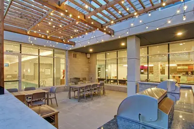 a patio with tables and chairs in a building at Home2 Suites By Hilton Montreal Dorval in Dorval
