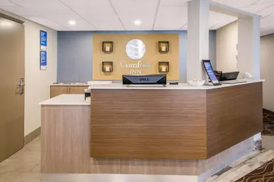 an office lobby with a counter with a laptop on it at Comfort Inn Aeroport in Dorval