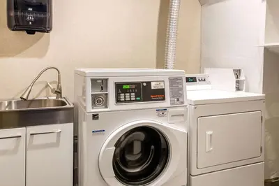 a washing machine in a kitchen next to a sink at Comfort Inn Aeroport in Dorval