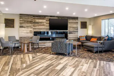 a hotel lobby with a couch and a piano at Comfort Inn Aeroport in Dorval