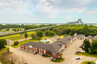 an aerial view of a building with a bridge in the background at Les Suites de Laviolette, an Ascend Collection Hotel in Trois-Rivières