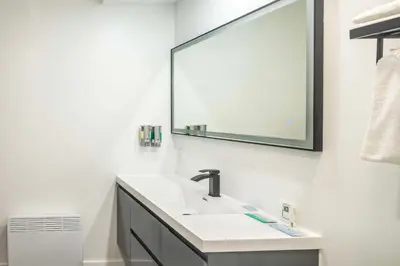 a bathroom with a sink and a mirror at Les Suites de Laviolette, an Ascend Collection Hotel in Trois-Rivières