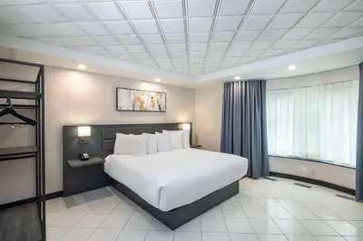 a bedroom with a large white bed and a window at Les Suites de Laviolette, an Ascend Collection Hotel in Trois-Rivières