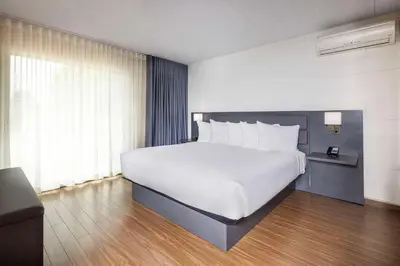 a bedroom with a large white bed and a window at Les Suites de Laviolette, an Ascend Collection Hotel in Trois-Rivières