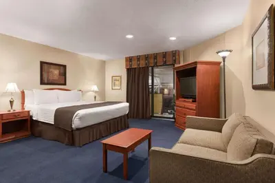 a hotel room with a bed and a couch at Hotel Days Inn Blainville & Centre de Conférence in Blainville
