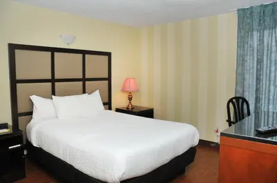 a hotel room with a bed and a desk with a lamp at Hotel Days Inn Blainville & Centre de Conférence in Blainville