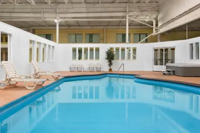 a large swimming pool with chairs and a tub at Hotel Days Inn Blainville & Centre de Conférence in Blainville