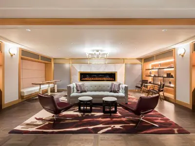 a living room with a couch and chairs and a table at Fairmont The Queen Elizabeth in Montréal