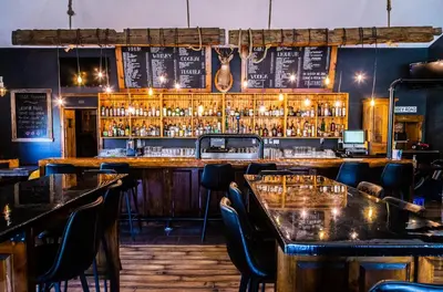 a bar with tables and chairs in a restaurant at Hotels Hébert in Bécancour