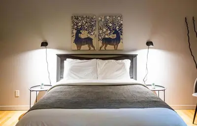 a bedroom with a large bed with two lamps at Hotels Hébert in Bécancour
