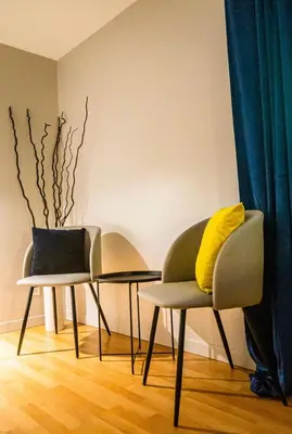 two chairs and a table and a vase in a room at Hotels Hébert in Bécancour