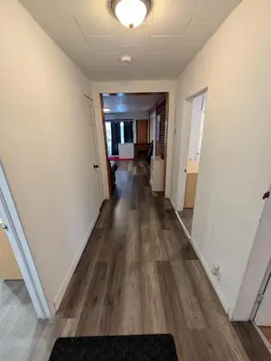 an empty hallway of an office building with wood floors at Motel LA RÉFÉRENCE in Trois-Rivières