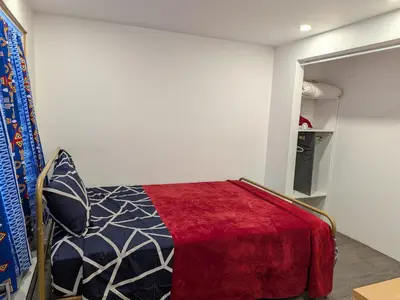 a bedroom with a bed with a red blanket at Motel LA RÉFÉRENCE in Trois-Rivières