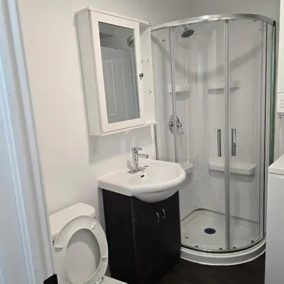 a bathroom with a shower and a toilet and a sink at Motel LA RÉFÉRENCE in Trois-Rivières