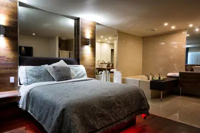 a bedroom with a large bed and a bathroom at Le Deauville Motel in Trois-Rivières