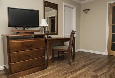 an office with a desk with a television and a mirror at Le Deauville Motel in Trois-Rivières