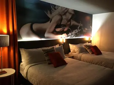 a hotel room with two beds and a picture on the wall at Hotel Historique et Manoir Route 66 in Saint-Victor