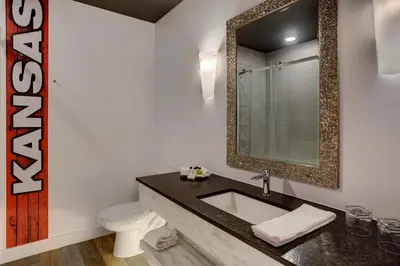 a bathroom with a sink and a toilet and a mirror at Hotel Historique et Manoir Route 66 in Saint-Victor
