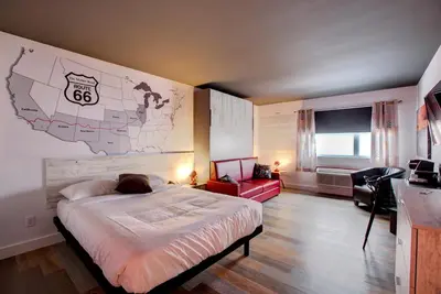 a bedroom with a bed and a map on the wall at Hotel Historique et Manoir Route 66 in Saint-Victor
