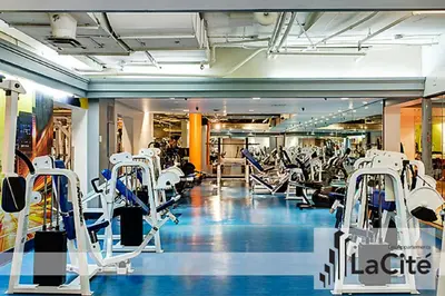 a gym with lots of treadmills and machines at LaCité Cozy Apartment Close to Central Montreal in Montréal