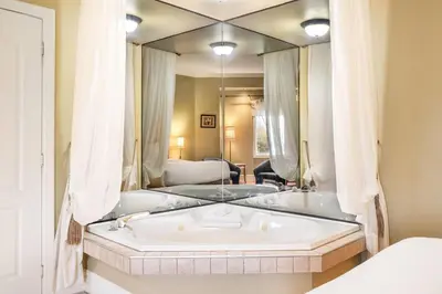 a bath tub in a room with a large mirror at Days Inn by Wyndham Berthierville in Berthierville