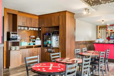 a restaurant with two tables and chairs and a kitchen at Days Inn by Wyndham Berthierville in Berthierville