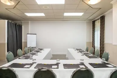 a conference room with white tables and chairs at Days Inn by Wyndham Berthierville in Berthierville