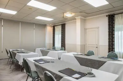 a conference room with white tables and chairs at Days Inn by Wyndham Berthierville in Berthierville