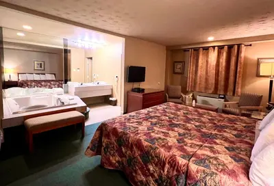 a hotel room with a large bed and a bathroom at Hotel L'Express in Longueuil