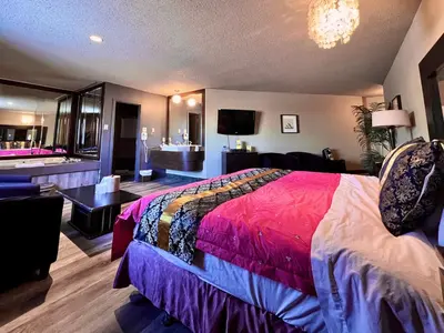 a bedroom with a large bed and a living room at Hotel L'Express in Longueuil